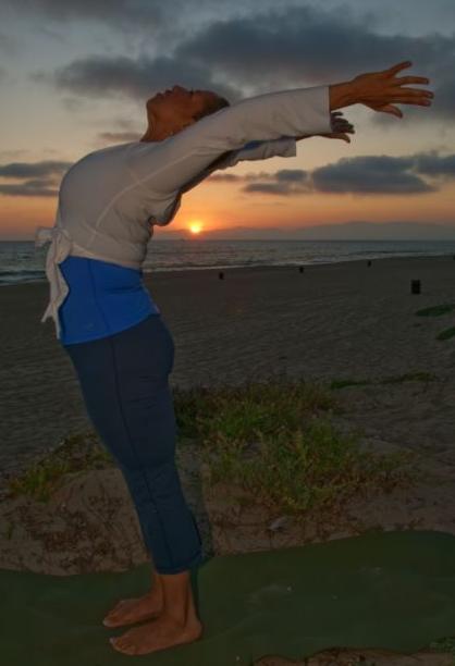 Black woman in crescent moon pose at sunset